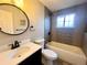 Updated bathroom with modern vanity, round mirror, bathtub, and tiled shower at 1088 Douglas Dr, Denver, CO 80221