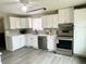 Bright kitchen with white cabinetry, stainless steel appliances, and modern countertops at 1088 Douglas Dr, Denver, CO 80221