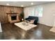 Inviting living room featuring a brick fireplace, hardwood floors, and ample natural light at 1088 Douglas Dr, Denver, CO 80221