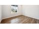 Bright bedroom featuring wood-look flooring, a large window, and neutral-colored walls at 9996 Racine St, Commerce City, CO 80022