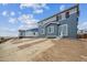 Two-story home with gray and blue siding, offering a bright interior and modern design at 9996 Racine St, Commerce City, CO 80022
