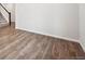 Spacious room featuring wood-look flooring, neutral walls, and staircase access at 9996 Racine St, Commerce City, CO 80022