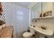Compact bathroom featuring a pedestal sink, toilet, and a shower with patterned curtain at 2886 S Acoma St, Englewood, CO 80110