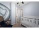 Bright Bedroom featuring a white crib, a decorative wall painting, and a rocking chair at 2886 S Acoma St, Englewood, CO 80110