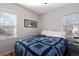 Cozy bedroom features a patterned comforter, wood floors, natural light from two windows at 2886 S Acoma St, Englewood, CO 80110
