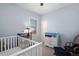 Light and airy Bedroom with a crib, changing table, and soft blue walls at 2886 S Acoma St, Englewood, CO 80110