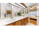 Bathroom with a double sink vanity, large mirror, and a view to the main bedroom at 2897 W Riverwalk Cir # 204, Littleton, CO 80123
