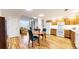 Well-lit kitchen featuring white appliances, light wood cabinetry, and adjacent dining space at 2897 W Riverwalk Cir # 204, Littleton, CO 80123