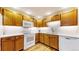 Bright kitchen featuring white counters, white appliances, and light wood cabinets at 2897 W Riverwalk Cir # 204, Littleton, CO 80123