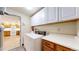 Well-equipped laundry area with a washer, dryer and additional cabinet storage at 2897 W Riverwalk Cir # 204, Littleton, CO 80123