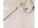 Close up of a white tiled shower with grab bar and adjustable shower head at 2897 W Riverwalk Cir # 204, Littleton, CO 80123