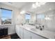 Bright bathroom features a double sink vanity, a large mirror, and views from two windows at 1408 Brookfield Pl, Lafayette, CO 80026