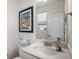 Well-lit bathroom featuring a white marble vanity, decorative mirror, framed artwork, and neutral paint at 1408 Brookfield Pl, Lafayette, CO 80026