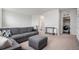 Comfortable living room with neutral walls, carpet, sectional sofa, and laundry room access at 1408 Brookfield Pl, Lafayette, CO 80026