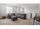 Inviting living room has a large sectional sofa, ottoman, and nearby staircase at 1408 Brookfield Pl, Lafayette, CO 80026