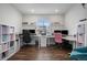 Bright office space with two work stations, modern shelving and storage, and a large window with a neighborhood view at 1408 Brookfield Pl, Lafayette, CO 80026