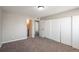 Bedroom featuring neutral paint, newer carpet, closet, and an ensuite bathroom at 18071 E Kentucky Ave # 203, Aurora, CO 80017