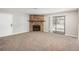 Open living room with a stone fireplace, sliding glass door, and view into the kitchen at 18071 E Kentucky Ave # 203, Aurora, CO 80017