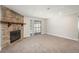 Spacious living room with a stone fireplace and sliding glass door to the balcony at 18071 E Kentucky Ave # 203, Aurora, CO 80017