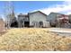 Exterior view of the home featuring a stone patio, partial deck, and lawn at 2305 Dogwood Cir, Erie, CO 80516