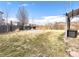 Large fenced backyard with mature trees, stone area, and a well-maintained lawn at 2305 Dogwood Cir, Erie, CO 80516