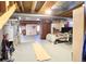 Unfinished basement with painted floor, exposed ceiling, and partially furnished living space at 2305 Dogwood Cir, Erie, CO 80516