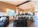 Open-concept dining area with wainscoting, modern lighting, and an adjacent living area at 2305 Dogwood Cir, Erie, CO 80516