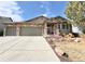 Charming ranch home featuring a three-car garage, stone accents, and beautiful landscaping at 2305 Dogwood Cir, Erie, CO 80516
