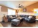 Comfortable living room featuring a large sectional sofa, stylish ceiling fan, and natural light at 2305 Dogwood Cir, Erie, CO 80516