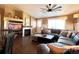 Comfortable living room with fireplace, sectional sofa, ceiling fan, and large windows at 2305 Dogwood Cir, Erie, CO 80516