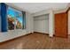 Bedroom with hardwood floors, closet, and large window at 15925 E 13Th Ave, Aurora, CO 80011