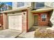 Charming townhouse exterior with brick accents, a two-car garage and a well-maintained front yard at 15925 E 13Th Ave, Aurora, CO 80011