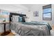 Comfortable bedroom features a stylish bed, side table with lamp, and a large window offering natural light at 3295 Blake St # 301, Denver, CO 80205