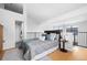 Bright bedroom boasts a modern design, hardwood floors, a stylish bed, and access to a full bathroom at 3295 Blake St # 301, Denver, CO 80205