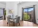 Dining area features a glass table, four chairs, and a sliding door with natural light at 3295 Blake St # 301, Denver, CO 80205