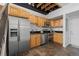 Well-equipped kitchen features stainless steel appliances and wooden cabinetry with stairs nearby at 3295 Blake St # 301, Denver, CO 80205