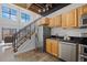 Modern kitchen with wood cabinets, stainless steel appliances, and tile flooring near staircase at 3295 Blake St # 301, Denver, CO 80205