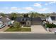 Aerial view of a brick home with a large driveway, three-car garage, and well-maintained landscaping at 5708 Wetland Loop, Frederick, CO 80504