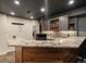Basement bar featuring stone counters, wood accents, sink and stainless steel fridge at 5708 Wetland Loop, Frederick, CO 80504