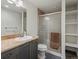Bathroom with granite countertop, shower, and open shelving unit at 5708 Wetland Loop, Frederick, CO 80504