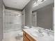 Bathroom featuring a vanity, toilet, and a shower-tub combo with glass doors at 5708 Wetland Loop, Frederick, CO 80504