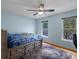 Bedroom with hardwood flooring, a ceiling fan, and large windows bringing in natural light at 5708 Wetland Loop, Frederick, CO 80504