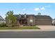 Charming brick home with a well-manicured lawn, dormer windows, and a three-car garage at 5708 Wetland Loop, Frederick, CO 80504