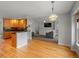 Open-concept kitchen with wood cabinets, black countertops, and hardwood floors leading to the living room at 5708 Wetland Loop, Frederick, CO 80504
