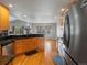 Bright kitchen with wood cabinets, dark countertops, stainless steel appliances, and wood floors at 5708 Wetland Loop, Frederick, CO 80504