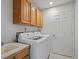 Functional laundry room with sink and cabinets for additional storage at 5708 Wetland Loop, Frederick, CO 80504