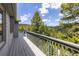 Long balcony with railing overlooking stunning mountain views and lush green trees at 6882 Snowshoe Trl, Evergreen, CO 80439