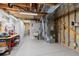 Unfinished basement with exposed ceilings and ductwork, utility sink, and heater at 6882 Snowshoe Trl, Evergreen, CO 80439