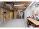 Unfinished basement with exposed ceilings, workbench, and storage area at 6882 Snowshoe Trl, Evergreen, CO 80439