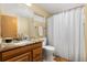 This bathroom features a vanity with granite countertop, toilet, and a shower with a white curtain at 6882 Snowshoe Trl, Evergreen, CO 80439